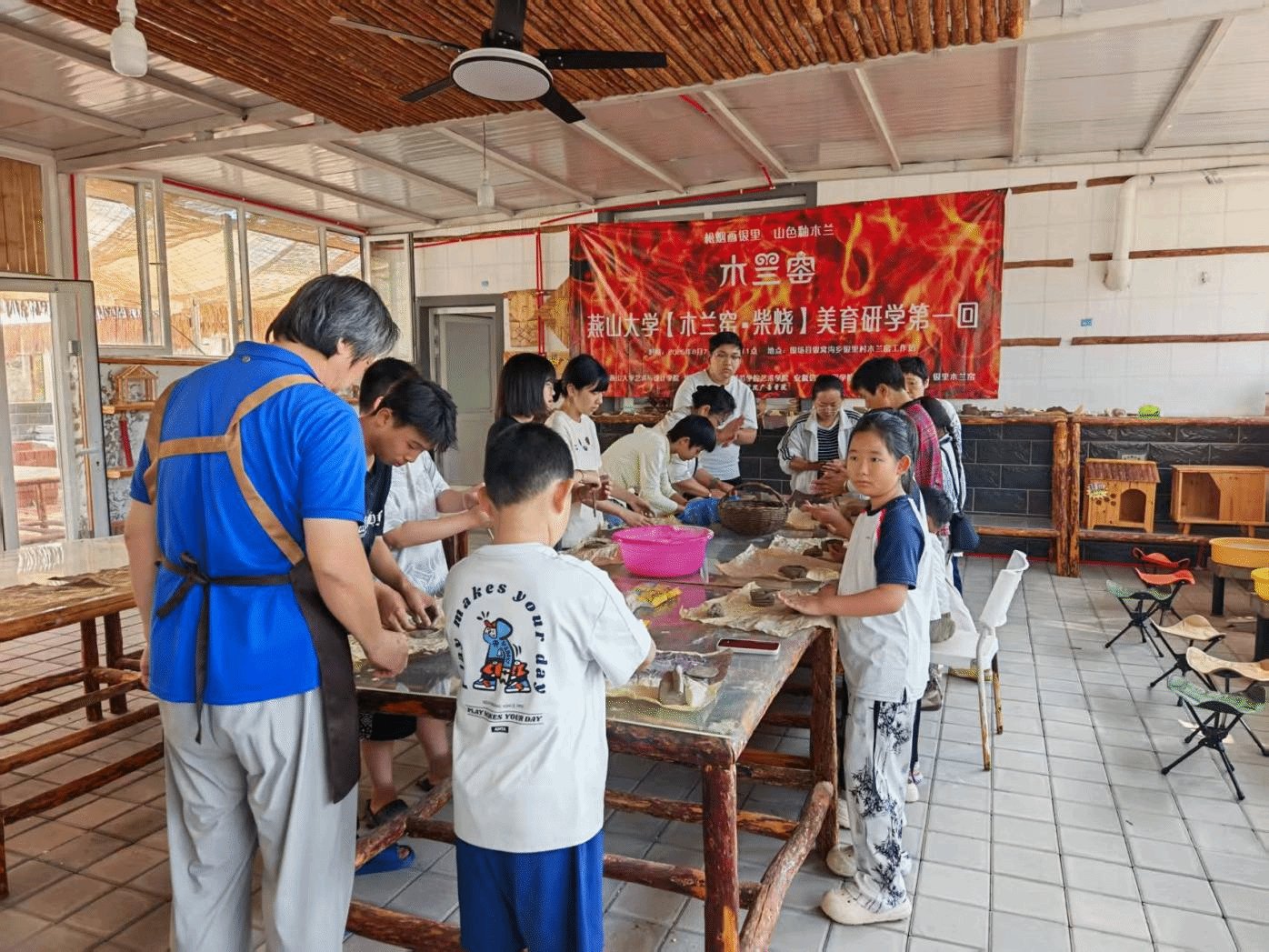 孩子们在陶艺专家的指导下制陶拉坯